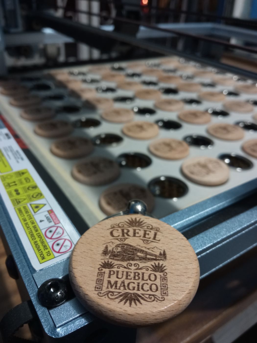 Máquina láser grabando llaveros Creel Pueblo Mágico